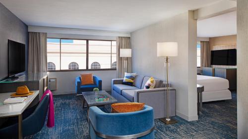 a hotel room with a couch and a bed at Hotel Dena, Pasadena Los Angeles, a Tribute Portfolio Hotel in Pasadena