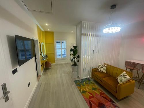 a living room with a couch and a table at Stylish Studio in Colchester