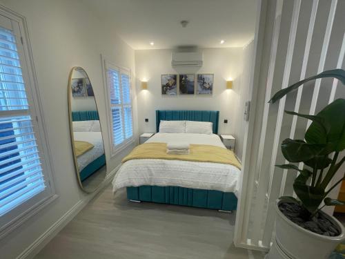 a bedroom with a bed and a large mirror at Stylish Studio in Colchester