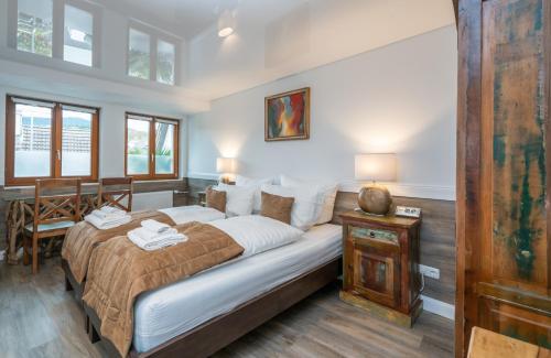 1 dormitorio con 1 cama grande y 1 mesa en RISA Hotel Village - Engel & Kreuz, en Gaggenau
