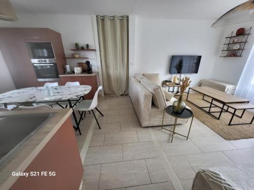 un salon avec un canapé et une table dans l'établissement Bienvenue chez ANOUK, à Châlons-en-Champagne