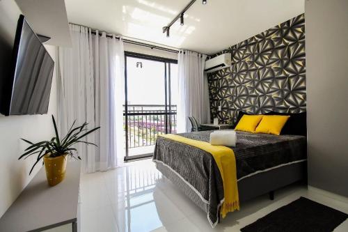 a bedroom with a bed and a large window at LF101 - Studio decorado no Tatuapé (Metrô a 250m) in Sao Paulo