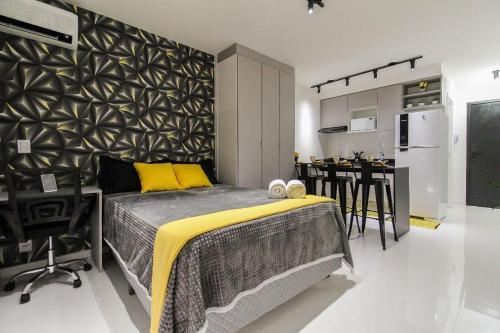a bedroom with a large bed and a kitchen at LF101 - Studio decorado no Tatuapé (Metrô a 250m) in Sao Paulo