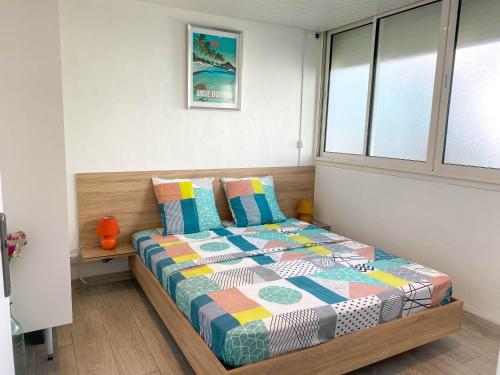 - une chambre avec un lit doté d'une couette colorée dans l'établissement Charmant T3 coeur Marina, à Les Trois-Îlets