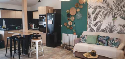 un salon avec un canapé et une cuisine dans l'établissement Maison 3 étoiles , proche plages, Cotinière, & St Pierre, à La Cotinière