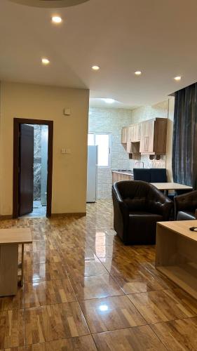 uma sala de estar com um sofá preto e uma cozinha em شقق الرفيق الفندقية em Aqaba