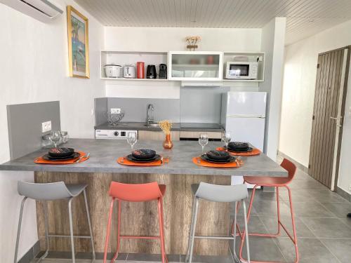 une cuisine avec un comptoir, des chaises et une table dans l'établissement Charmant T3 coeur Marina, à Les Trois-Îlets