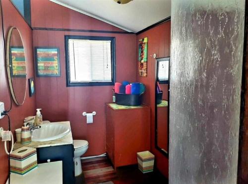 a red bathroom with a toilet and a sink at West Lake Waterfront Swimming - Free Pontoon Boat! in West Lake