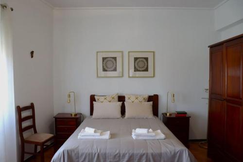 een slaapkamer met een bed met twee handdoeken erop bij Judith House - Amadora Este in Amadora