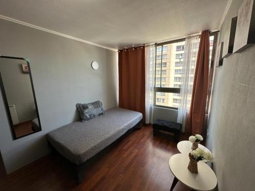 a small room with a couch and a window at Apartamentos Orquídea Suite in Santiago