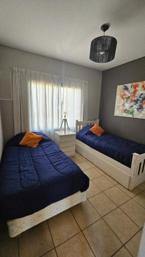 a bedroom with two beds and a window at Dpto. Mendoza in Godoy Cruz