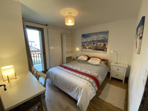 a bedroom with a bed and a desk and a window at les 7 laux immobilier chalet E in Prapoutel