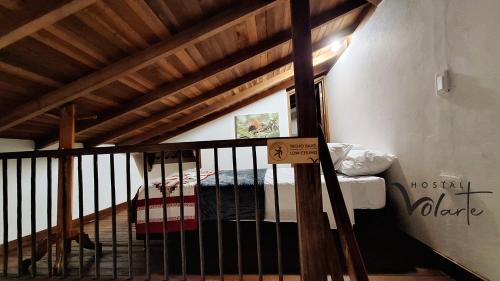 a bunk bed in a room with a wooden ceiling at Volarte Hostal in Jardin