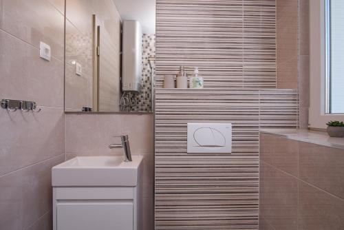 a bathroom with a sink and a toilet in it at Villa Barbara & Zoran with free parking and heated swimming pool in Seget Vranjica