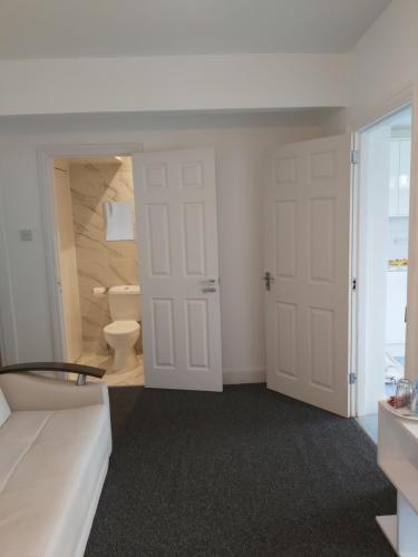 ein Bad mit einem WC und einer weißen Tür in der Unterkunft Fresher Space Home Stay in Birmingham