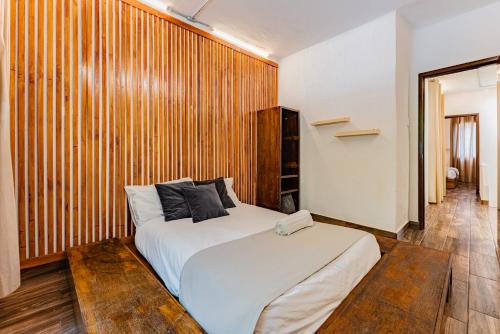 1 dormitorio con 1 cama y pared de madera en Espaciosa y Lujosa Casa en la Condesa con Roof Top en Ciudad de México
