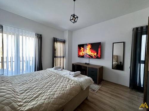 a bedroom with a bed and a tv on the wall at Mihail Apartments Mavrovo in Mavrovo