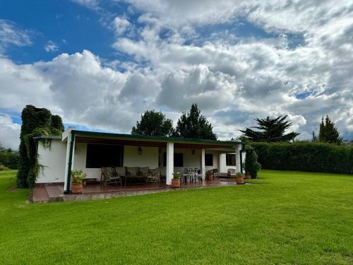 a white house with a patio and a lawn at Descanso Perfecto en Tafí del Valle in Tafí del Valle