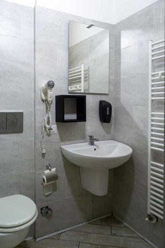 een badkamer met een wastafel, een toilet en een spiegel bij Affittacamere Limin in Busto Arsizio