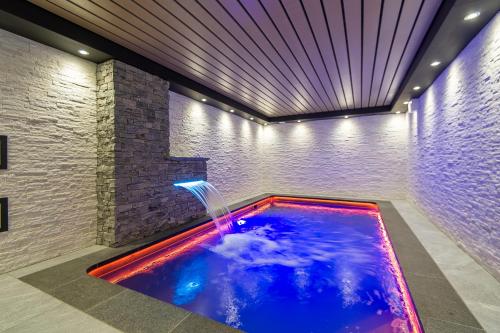 - une piscine avec une fontaine dans une chambre dans l'établissement Chalet Evidence, à Montvalezan