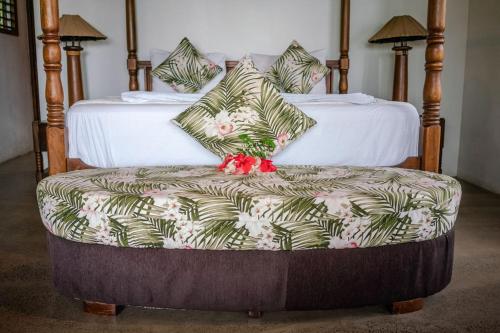 a bedroom with two beds and a bench with a couch at Fiji Bucket in Tangangge