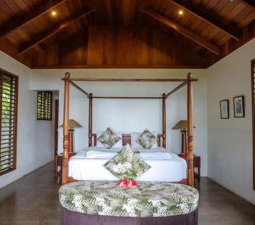 a bedroom with a large bed and a large ottoman at Fiji Bucket in Tangangge