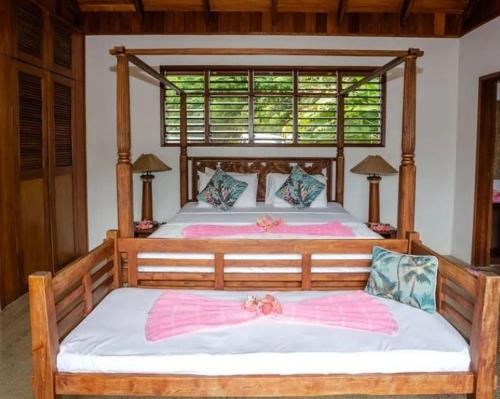 a bedroom with two beds and a large window at Fiji Bucket in Tangangge