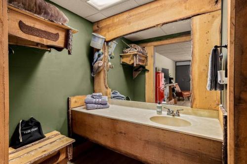 La salle de bains est pourvue d'un lavabo et d'un miroir. dans l'établissement Stonegate Lodge King Bed, WIFI, 50in Roku TV, Salt Water Pool Room #110, à Eureka Springs