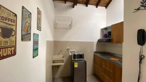 une cuisine avec un réfrigérateur et un téléphone au mur dans l'établissement Apartaestudios tipo loft Prado Station, à Medellín