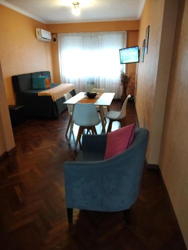 sala de estar con mesa y silla azul en Apartamento El Colón en Buenos Aires