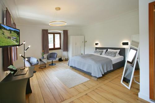 Dormitorio con cama, escritorio y TV en Bed & Breakfast Müllers Klostermühle, en Münstertal