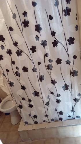 a bathroom with a shower curtain with flowers on it at Departamento para 4 personas San Clemente in San Clemente del Tuyú