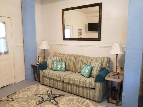 a living room with a couch and a mirror at The Seahorse Apt - Lakeside and Close to the Beach in Galveston