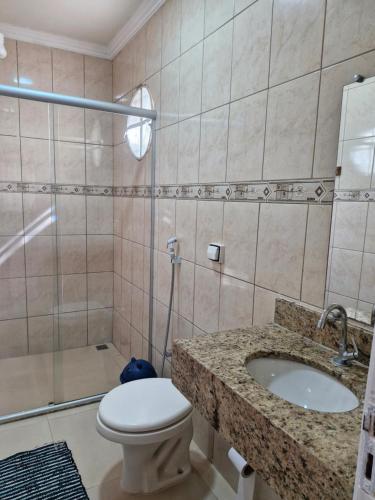 a bathroom with a toilet and a sink and a shower at Encantu's Flats in Itatiaia