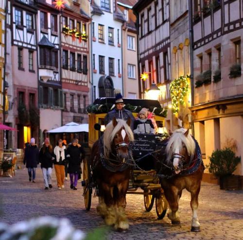 a man riding a horse drawn carriage down a street at RentApart`s Nürnberg City Smart in Nuremberg