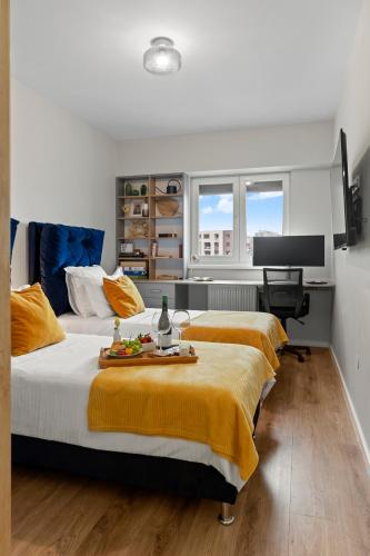 a bedroom with two beds and a desk in it at Mido Park Apartment with Private Parking & Self Check-in in Bucharest
