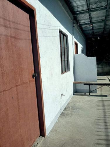 una porta di un edificio con una panchina accanto di APARTMENT FOR RENT a Baliuag