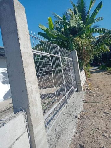 una recinzione sul lato di una spiaggia con palme di APARTMENT FOR RENT a Baliuag