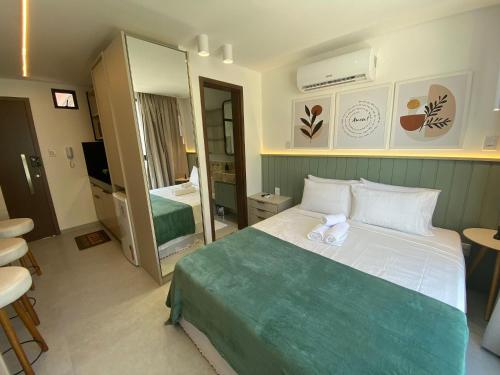 ein Hotelzimmer mit einem Bett und einem Spiegel in der Unterkunft Bela Hospedagem - #Sunrise 204 in João Pessoa