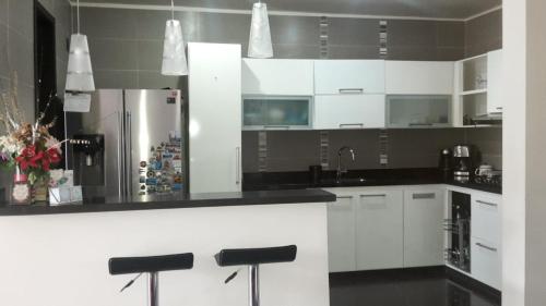 a kitchen with white cabinets and black counter tops at Casa Provenza Bucaramanga in Bucaramanga