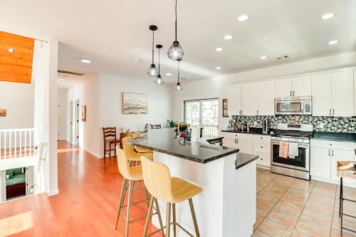 a kitchen with white cabinets and a island with bar stools at Deck and Lake View Spacious Long Pond Home! in Long Pond