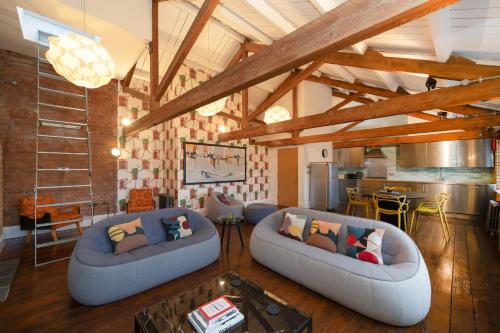 a living room with two couches and a kitchen at Crashpads Shoreditch Apartments - The Club Row Collection in London