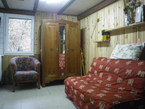 ein Wohnzimmer mit einem Sofa und einem Stuhl in der Unterkunft Chambre quadruple du grand sapin 