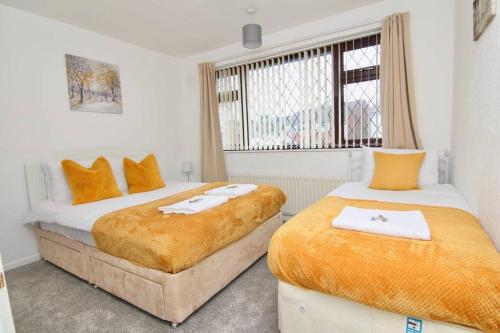 um quarto com 2 camas e toalhas em 3Bed Gem Near Coventry Building Society Arena em Coventry