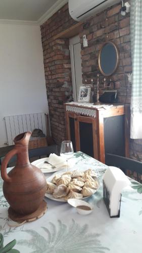 a table with a vase and a plate of food at Green Lake Vashlovani in Kasristsqali