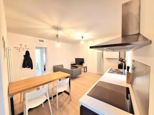 uma cozinha e sala de estar com uma mesa de madeira num quarto em Varano 7 em Ancona