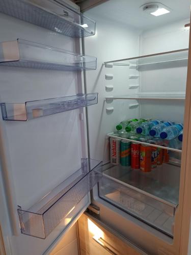 an open refrigerator with drinks and soda cans in it at Apartmani Janjic in Banja Luka