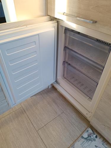 an empty refrigerator with its door open in a kitchen at Apartmani Janjic in Banja Luka
