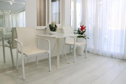 Mia apt. في إزمير: غرفة طعام بيضاء مع طاولة بيضاء وكراسي