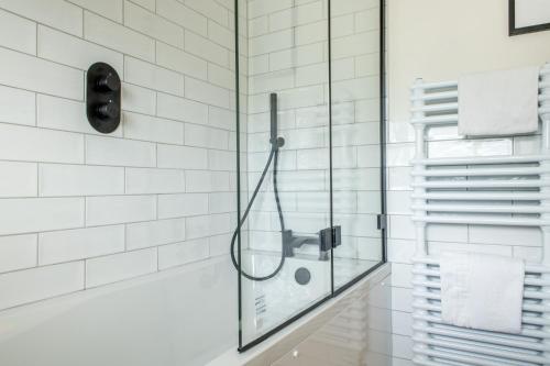 a glass shower in a bathroom with white tiles at Luxury Stay at Oakmere Lodge in Oxton